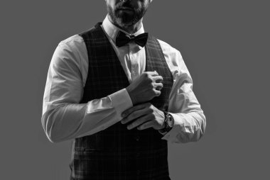 Papyonlu adam gride izole edilmiş. Zarif siyah takım elbiseli şık bir adam. Smokinli bir beyefendi. Resmi etkinlikteki iş adamı. Damadın smokin tarzı var. Centilmen smokini. Smokin, kırpık manzara..