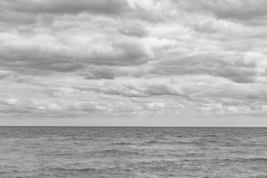 Deniz ufku manzarası. Bulutlu gökyüzü ve deniz manzarası. Deniz ufkuyla gökyüzü. Deniz doğasına sakin bir ufuk açısı. Deniz manzarasında bulutlu havada dramatik bir gökyüzü.
