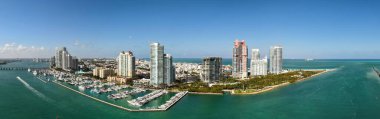 Miami silueti ve Biscayne Körfezi Panoraması. Kıyı gökdelenleri olan panoramik şehir manzarası. Miami Beach 'in yukarıdan manzarası. Drone Fisher Adası 'nı ve limanı ele geçirdi.