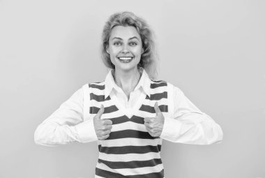 Beyaz, genç, şık bir iş kadını. Kızıl saçlı kadın gündelik tarzda. Sıradan moda. Profesyonel iş kadını şirket lideri. Kadın yönetici sarıda tek başına duruyor. Başparmak yukarı..