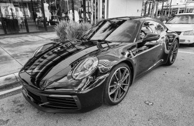 Miami Beach, Florida USA - 8 Haziran 2024 Porsche 911 Carrera 4S Miami Beach 'te siyah. Ocean 'daki lüks araba porshche Miami plajına gidiyor..
