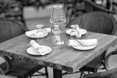 Çanak çömlek ve peçete restorandaki masada. Servis için seramik boş tabaklar. Lüks yemekler servis etmek için yemek takımı. Masa ayarı. Ahşap masada bir takım temiz sofra takımı.