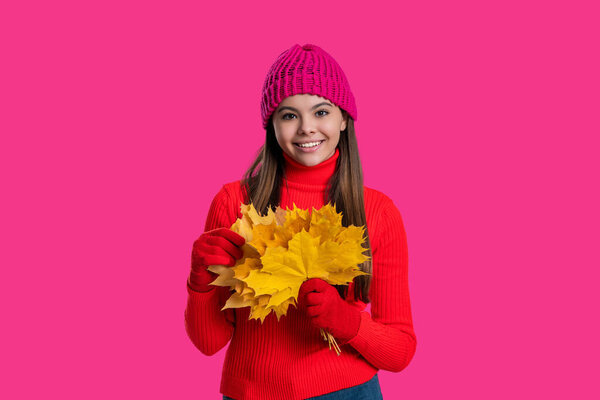 Autumn leaves in hand of teen girl. Autumn leaves and teen young girl isolated on pink. Teenager girl in autumn hat. Fall leaves. Girl in fall style. Fall style fashion. Leaf peeping.