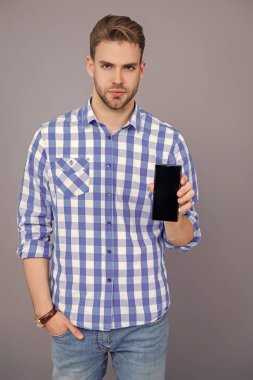 Ürünü sunuyorum. İş uygulamasının reklamı. Milenyum iş adamı telefon ekranını sunuyor. İş adamı Grey 'de izole edilmiş bir telefon gösteriyor. Yeni iş telefonu uygulaması gösteren bir adam.