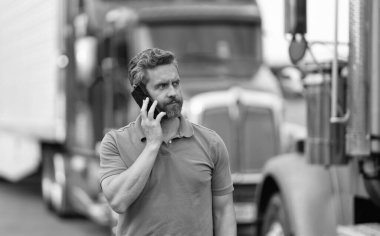 Olgun bir İspanyol kamyon şoförü ve sahibi açık hava telefon görüşmesi yapıyor..