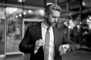 İş hayatına geç kalan bir iş adamı. Zaman yönetimi. Dakik adam kontrol süresini geç geçti. Nöbetçi bir iş adamı. Dakik iş adamı dışarıda zamanı kontrol ediyor. Toplantıyı bekliyorum. İş teslim tarihi.