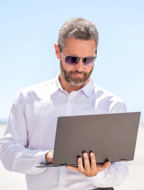 Açık havada serbest çalışan bir iş adamı. Serbest geliştirici internet üzerinden iş yapıyor. İş adamı. İş başarısı. Adam maili kontrol ediyor. Başarılı iş adamı çevrimiçi serbest çalışma, kopyalama alanı.