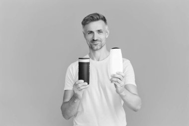 Erkek kozmetik ürününü sunuyorum. Adam şampuan kullanıyor. Olgun adam saç kremi kullanır. Tıraş losyonlu adam. Günlük alışkanlık ve kişisel bakım. Cilt kozmetiği. Tıraş losyonu. Doğru ürünleri seç.