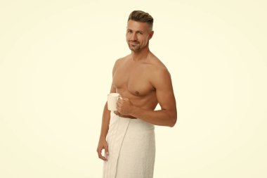 Gövdesi olan yakışıklı bir adamın sabah kahvesi. Duştan sonra üstsüz adam. Kaslı gövdeli olgun bir adam evde çay ya da kahve içerken beyaz tenli. Sabah rutini.