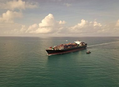 Hava görüntülü kargo gemisi limana giriyor. Kargo işi. Konteyner gemisi. Nakliye lojistiği. Ticari nakliye. Kargo gemisi denizde, hava manzaralı. Nakliye konteynırı. Ağır kargo nakliyesi.