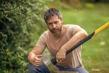 Oduncu keskin balta bıçağını kontrol et. Baltalı terli adam. Ormanda baltayla oduncu. Ağır baltalı oduncu. Güçlü terleyen adam ormanda çalışır. Baltalı oduncu ormanda..