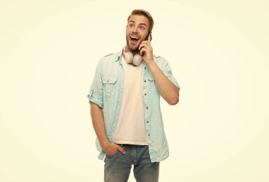 Cep telefonuyla konuşan bir adam. Telefon var. Mobil bağlantı. Kulaklıklı adam. Öğrenci yaşam tarzı. Modern iletişim. Telefonda konuşan adam beyazdan soyutlanmış. Millennial Man 'e telefon var. Merhaba..