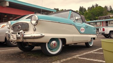 Astoria, Oregon, ABD - 21 Mayıs 2019: Nash Metropolitan üstü açılır araba. Nash Metropolitan 'ın üstü açık arabası. Nash Metropolitan beyaz ve mavi. Nash Metropolitan açık hava, alçak manzara.