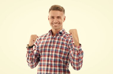 Kareli gömlekli mutlu adamın başarısı. Başarıyı kutluyoruz. Başarılı bir erkek portresi. Mutluluk ve başarıyı ifade etmek. Beyazların arasında yalnız, mutlu, olgun bir adam. İş yerinde başarılı bir proje.