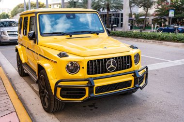 Miami, Florida, ABD - 26 Ocak 2025: Mercedes Benz hibrit araba açık havada park edildi. Sarı araba, köşe manzaralı. 2025 Mercedes Benz G sınıfı hibrit araba. Lüks elektrikli ve motorlu Mercedes Benz G sınıfı..