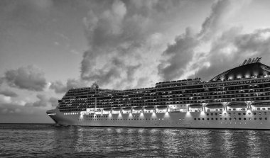 Gece limanında gemi. Lüks deniz tatili. Gemi seyahati. Yaz tatilinde Majestic yolcu gemisi. Gemi seyahati ve deniz seyahati. Aydınlatılmış lüks yolcu gemisi manzarası. Kocaman bir yolcu gemisi..