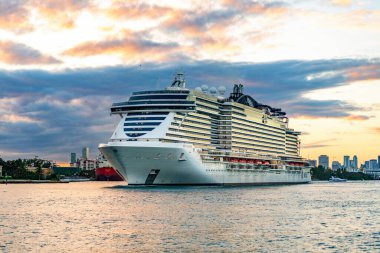 Miami, Florida, ABD - 23 Aralık 2024: MSC yolcu gemisi. Gemi turu ve deniz seyahati. Gün batımında aydınlatılmış gemi. MSC Sahil Yolcu Gemisi Yolculuğu. Yaz tatilinde gezmek.