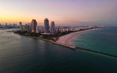 Miami Sahili Günbatımı hava manzarası. Alacakaranlıkta Miami 'nin göbeğinde. Güney Sahili neon ışıkları. Tropik Miami kıyısı manzarası. Ocean Drive Art Deco binaları. Miami kıyı şeridinin havadan görüntüsü