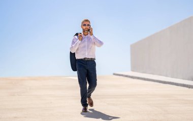 İş iletişimi. Telefona cevap veren adam. Zengin iş adamı dışarıda telefonla konuşuyor. Telefon kullanan bir iş adamı. Erkek telefon konuşması. Akıllı telefonlu İspanyol bir iş adamı. Akıllı görünüm.