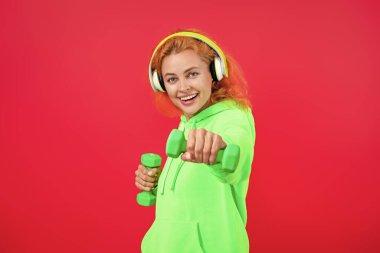 Spor salonunda spor aletleri olan kadın antrenmanı. Pembe üzerine izole edilmiş..