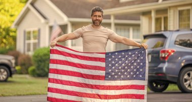 Bağımsızlık Günü için Amerikan Bayrağı ya da 4 Temmuz. Adam Amerikan bayrağını dışarıda tutuyor. Vatanseverlik sembolü olan bir vatansever. Amerikan bağımsızlığı. Ulusal bayrak. Bağımsızlık Günü.