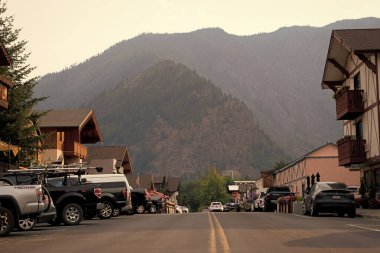 Leavenworth, Washington, ABD - 22 Temmuz 2024: Turistik kasaba. Washington, Leavenworth 'teki Bavyera köyünde yolda ve caddelerde park halindeki arabalarla. Eski kasabadaki yol. Bavyera köyü dağı.