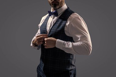 Damadın smokin tarzı var. Centilmen smokini. Smokin manzaradır. Papyonlu adam gride izole edilmiş. Zarif siyah takım elbiseli şık bir adam. Smokinli bir beyefendi. Resmi etkinlikteki iş adamı. Garson..