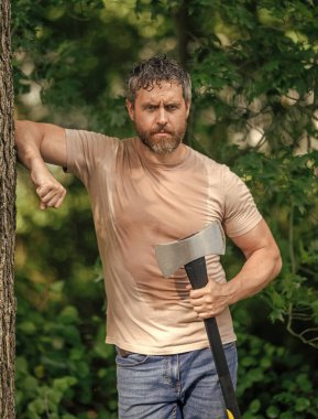 Ormanda baltayla dolaşan oduncu İspanyol adam. Oduncu baltayı taşır. Baltalı terli adam. Ormanda baltayla oduncu. Ağır baltalı oduncu. Güçlü terleyen adam ormanda çalışıyor..