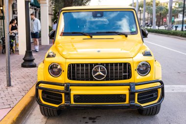 Miami, Florida, ABD - 26 Ocak 2025: Mercedes Benz hibrit araba açık havada park edildi. Sarı araba, ön manzara. 2025 Mercedes Benz G sınıfı hibrit araba. Lüks elektrikli ve motorlu Mercedes Benz G sınıfı..