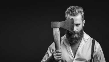 Antika pantolon askılı, eski tip bir gaddar adam. Siyaha izole edilmiş baltalı askılı vahşi bir adam. Saçları kızıl saçlı, olgun bir adam. Acımasız erkek modası. Erkek vahşeti. Boşluk afişini kopyala.