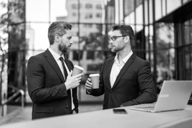 Çalışıyorum. İş adamları e-postaları kontrol ediyor. İş adamları dışarıda serbest çalışıyor. İnternette iş. Dizüstü bilgisayarda çalışan adamlar. Çevrimiçi çalışan iş adamları. Dizüstü bilgisayarlı iş adamları. Kahve molası.