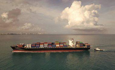 Konteyner gemisi. Nakliye lojistiği. Ticari nakliye. Kargo gemisi denizde, hava manzaralı. Kargo gemisinde nakliye konteynırı. Hava görüntülü kargo gemisi limana giriyor. Kargo işi. Nakliye endüstrisi.