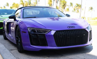 Miami, Florida, ABD - 4 Nisan 2025: Sportscar Audi R8. Araba Audi R8 süper arabası dışarıda park edilmiş. Mor spor araba, ön manzara. Audi R8 2017 spor araba..