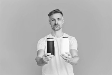 Adam şampuan kullanıyor. Olgun adam saç kremi kullanır. Tıraş losyonlu adam. Günlük alışkanlık ve kişisel bakım. Cilt güzellik kozmetiği. Şampuan ya da tıraş losyonu. Erkek kozmetik ürününü sunuyorum. Sağlıklı saçlar.