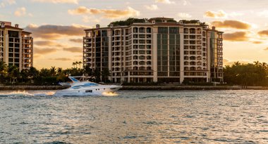 Marinaya yüzen bir tekne. Fisher Adası 'nda lüks bir yat teknesi. Yaz tatili. Fisher Adası konut binası ve lüks yat teknesi. Miami 'de Fisher Adası' na yat gezisi..