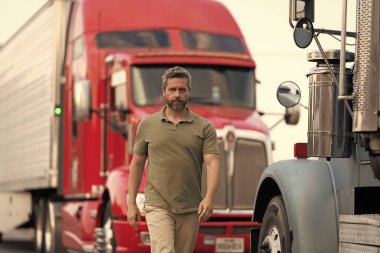 Kamyonun önünde yakışıklı bir şoför. Kamyon sahibi. Kamyon şoförü. Kamyon kamyonunun yanında bir erkek kamyon şoförü. Nakliye araçları. Yarı kamyon aracı. İspanyol kamyoncu adam. Kamyon sahibi.