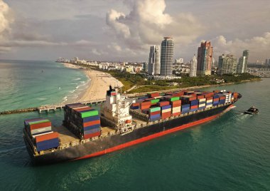 Kargo işi. Miami Limanı. Miami 'de konteynırlı kargo gemisi, hava manzaralı. Kargo gemisinde nakliye konteynırı. Kargo gemisi limandan ayrılıyor. Konteyner gemisi. İhraç ve ithalat. Güney Sahili.