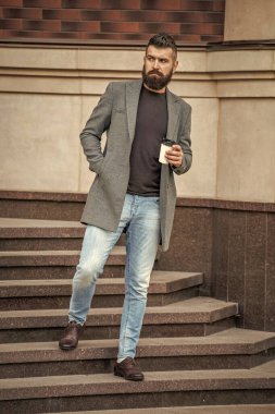 Günlük stil rutini. Sakallı adam şehir caddesinde kahve içiyor. Sokakta elinde kahve tutan yakışıklı bir adam. İş molası. Sabah kahvesi içen adam. Kahve molası. Binadan çıkıyorum..