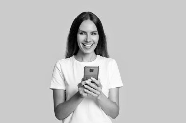 Kadın blogcu sarıda izole edilmiş akıllı telefon kullanıyor. İnternette ve blogda sörf yapmak. Sohbet ve mesajlaşma. Milenyum kadınları internette sohbet ediyor. Telefondaki kadın blogu. İletişim sohbeti. İnternetten al.