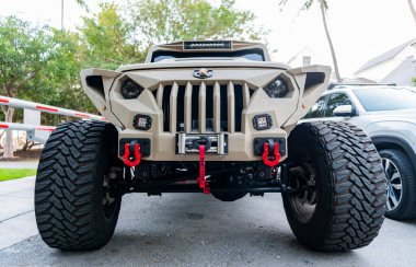 Miami, Florida, ABD - 16 Şubat 2025: Araba Jeep Gladyatörü açık havada park etti. Bej kamyonet, ön manzara. Jeep Gladyatör 2024 arabası. Kamyonet arabası Jeep Gladyatörü.