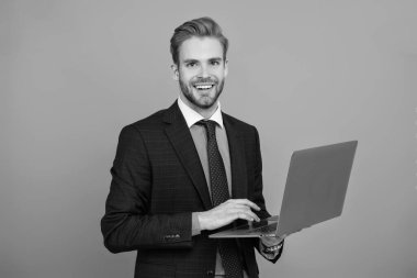 Grey 'de izole edilmiş dizüstü bilgisayar kullanan bir iş adamı. Çevrimiçi çalışan serbest çalışan biri. Adamın online blogu var. Ofisinde dizüstü bilgisayarla takım elbiseli bir iş adamı. Uzaktan kumandalı çalışıyor. İş blogu başarısı. E- posta cevaplanıyor.