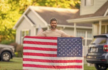 Vatanseverlik sembolü olan bir vatansever. Amerikan bağımsızlığı. Ulusal bayrak. Bağımsızlık Günü. Bağımsızlık Günü için Amerikan Bayrağı ya da 4 Temmuz. Adam Amerikan bayrağını dışarıda tutuyor. Anma Günü.