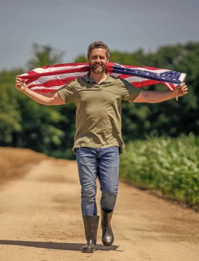 4 Temmuz. İşçi bayramı. Amerikan bayrağı ve İspanyol çiftçi, hasat zamanı. ABD bayrağı. Bağımsızlık Günü. Sahadaki adam. Sahada Amerikan bayrağı taşıyan vatansever adam. Amerika 'nın Bağımsızlık Günü.