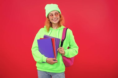 Üniversitede eğitim. Pembe üzerine izole edilmiş bir kızın ödevi. Bilgi ve eğitim. Okul eğitimi. Modern eğitim. Kız öğrenci çalışma kitabını tutuyor. Okula dönelim. Bilgi toplama günü. Bilgi yönetimi.