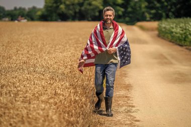 Amerikan İşçi Bayramı. Amerikan bayrağı ve çiftçi, tarım. ABD bayrağı. Bağımsızlık Günü. Sahadaki adam. Ekin tarlasında Amerikan bayrağı taşıyan adam. Amerika 'nın Bağımsızlık Günü. 4 Temmuz.