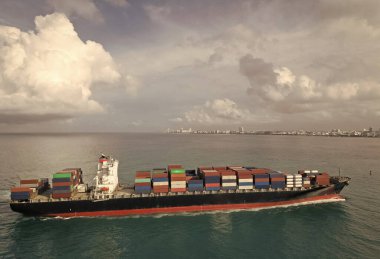 Ticari nakliye. Kargo gemisi denizde, hava manzaralı. Kargo gemisinde nakliye konteynırı. Hava gözlem gemisi limana giriyor. Kargo işi. Konteyner gemisi. Nakliye lojistiği. Ticari kargo filosu.