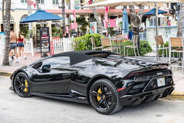 Miami, Florida, ABD - 13 Temmuz 2025 Lamborghini, köşe manzaralı. Lamborghini Huracan EVO 2020 üstü açık araba. Lüks siyah araba Lamborghini Huracan EVO. Lamborghini Huracan 'ın arabası dışarı park edilmiş..