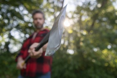 Acımasız oduncu. Oduncu tarzı. Baltalı bir adam. Balta adamın elinde odun kesiyor. Odun kesiyorum. Keskin bıçak. Vahşilik ve erkeklik. Seçici odaklı baltalı oduncu.