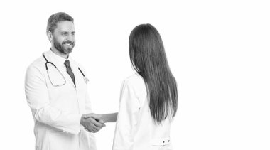 Doktor, hemşireyle tokalaşıyor. İki doktor beyazın üzerinde el sıkışıyor. Tokalaşma, hasta sağlığı konusunda anlaşma. Hastane takım çalışması işbirliği. Başarılı tedavi. Güçlü tokalaşma.