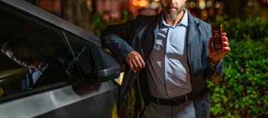 Değerli metallere yatırım. Altın külçe. Altın çubuk. Kesilmiş işadamı altın külçesini arabasında tutuyor. Finansal başarı. Altını olan başarılı zengin bir adam. İş başarısı altın çubuğu.